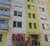 Apartment building on SNP in Nové Zámky with blooming shrubs in front of the entrance.