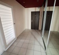A hallway in a 3-room apartment with tiled flooring, a mirrored wardrobe, and dark doors.