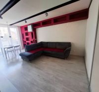 Living room in a 3-room apartment with a corner sofa, dining table, and floor with a wooden decor.