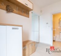 Entrance hall in a family house with wall hooks and entrance to the bathroom.
