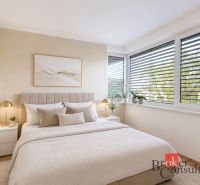 A bedroom in a family house with a comfortable bed, decor, and blinds on the windows.
