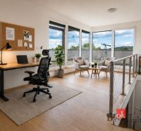 A workspace with a desk, chair, shelf, and wooden decor flooring in a family house.