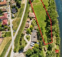 Recreational plots in Hamuliakovo by the river, surrounded by greenery and houses.