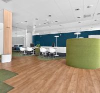 Office spaces with wood-patterned flooring and green furniture.