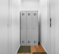 Narrow spaces with metal lockers and a wooden decor floor.