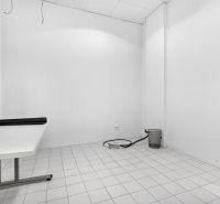An empty interior with white walls, a table, and white tiles in commercial premises.