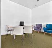 Commercial premises with a conference table, colorful armchairs, and simple chairs.