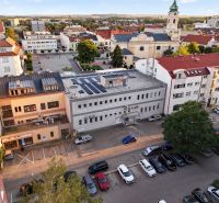 View of M.R. Štefánik in Topoľčany with commercial spaces and a church in the background.