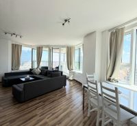 Bright living room with a sofa and wood-patterned flooring, 3-room apartment.