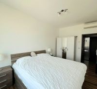 A bedroom with a double bed, a wardrobe, and a wooden decor floor in a 3-room apartment.