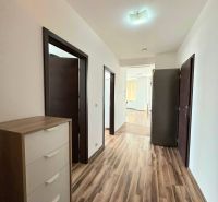 A hallway in a 3-room apartment with a wooden decor floor and white walls.