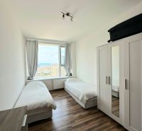A room with two beds and a wardrobe, a floor with a wooden decor in a 3-room apartment.
