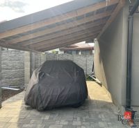 A family house on SNP Street in Čaňa with a shelter and a covered car.