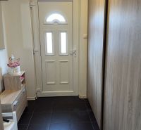 Entrance hall in a family house with white doors and furniture with a wooden decor.
