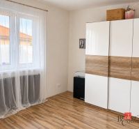 A white wardrobe with a wood decor and curtains in the room of a family house.