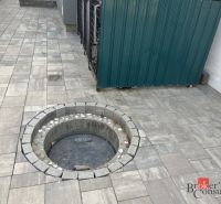 Along the concrete pavement of the family house on SNP in Čaňa, there is a circular manhole cover.