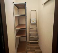 Storage space in a 2-room apartment with a shelving system and a ladder.