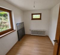 A room in a family house with a radiator and a wooden decor floor.