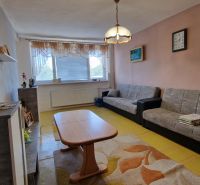 Living room with sofas, a coffee table, and a wooden decor floor in a family house.
