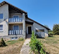 A family house on Biela Street in Kazimír, surrounded by a spacious garden and a blue sky.