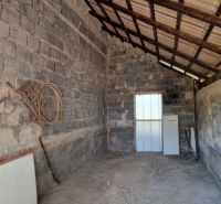 A shed with a sloped metal roof and concrete walls, located in a family house.