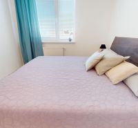A bright bedroom in a 3-room apartment with a light purple bedspread.