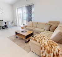 Living room in a 3-room apartment with a beige sofa and a dining table.