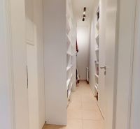 A narrow corridor with built-in shelves in a 3-room apartment.
