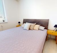 A bedroom with a large bed, nightstands, and decorative pillows in a 3-room apartment.