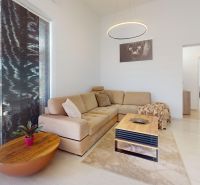 Living room with a cream sofa, light wooden-patterned floor, and a tasteful coffee table.