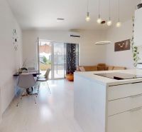 A kitchen with a dining table and a comfortable living area in a 3-room apartment.