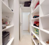 A white pantry with built-in shelves in a 3-room apartment, filled with various items.