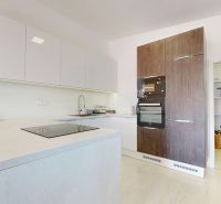 A kitchen in a 3-room apartment with white cabinets and a wooden decor floor.