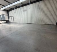 Spacious interior of warehouses and halls with high ceilings and concrete floors.