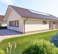 A family house in Tuchyňa with a sloped roof and a parking lot in front of the building.
