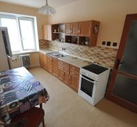 Kitchen in a 2-room apartment with a dining table, kitchen unit, and appliances.