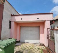 A family house on Šípošová Street in Šahy with a garage and waste bins.