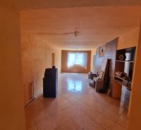 The interior of a family house with a ceramic floor and beige walls, illuminated by the spaces.