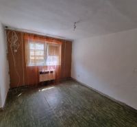 A room in a family house with a floor and windows with curtains.
