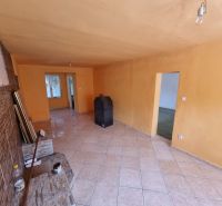 Living room in a family house with orange walls and tiles.