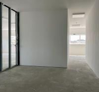 Interiors of warehouses and halls with transparent glass partitions and concrete floors.