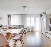 A bright living room in a two-room apartment with a wooden decor floor, stylish furniture, and decorations.