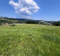 Green meadows in Olešná suitable for residential plots, surrounded by nature and hills.