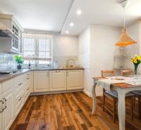 A kitchen in a 4-room apartment with a wooden decor floor and a dining area.