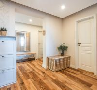 Interior of a 4-room apartment with a wooden decor floor, a dresser, and a mirror.