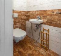 Bathroom in a 4-room apartment with a toilet, sink, and decorative wall tiles.
