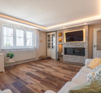 Living room in a 4-room apartment with a fireplace, wooden decor flooring, and comfortable seating.