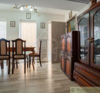 A dining room in a cabin with wooden floor decor, featuring elegant furniture and natural light.
