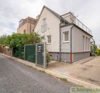 The exterior of the cottage in Senec with a paved driveway and lush vegetation.