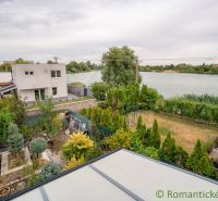 View from the cottage by the lake in Senec, surrounded by a lush garden.